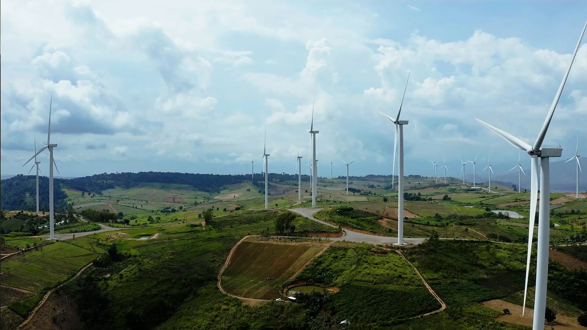 Visuel Sandvik montrant un parc éolien dans un paysage vallonné, illustrant les produits et services industriels liés aux énergies renouvelables
