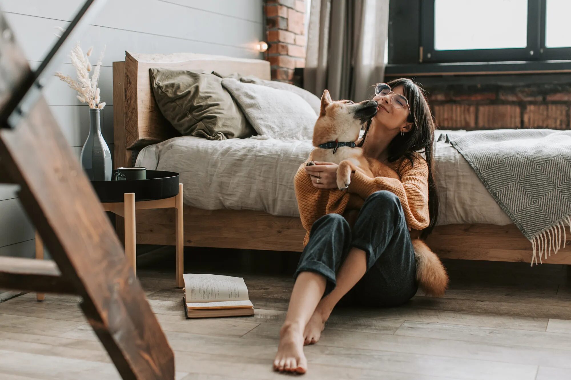 Visuel Goodflair pour assurance santé animale, montrant une femme assise dans une chambre avec son chien dans une ambiance chaleureuse et rassurante