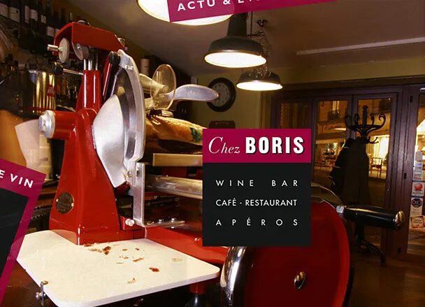 Intérieur du bar à vin Chez Boris avec trancheuse à jambon rouge, ambiance chaleureuse de café-restaurant et identité visuelle élégante